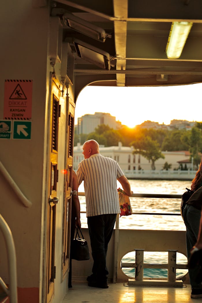 An elderly man enjoys a scenic sunset view from a ferry, highlighting tranquility and travel.